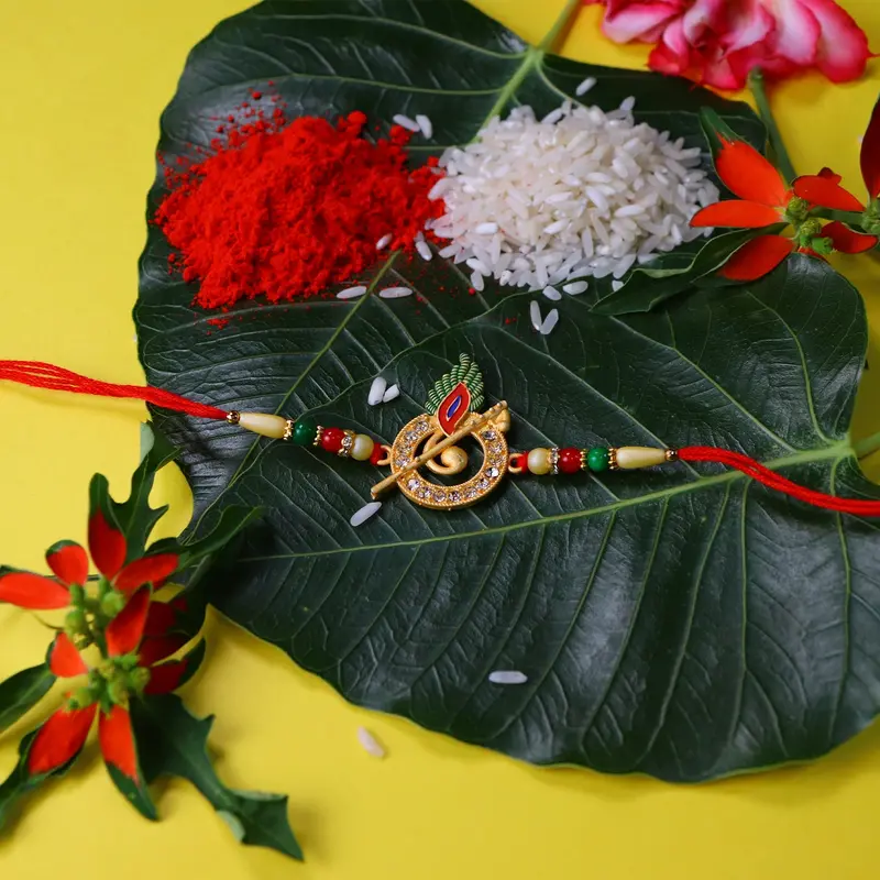 Krishna Flute-Themed Rakhi Featuring Embellished Peacock Feather Motif 1